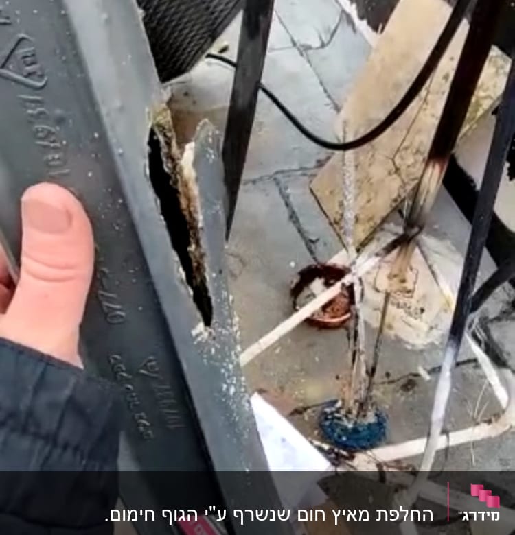 צינור סולארי פגום עם חור גדול, יד מחזיקה בצינור